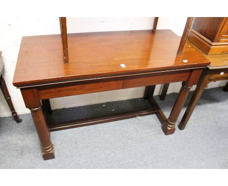 A mahogany console table with two frieze drawers on gun barrel turned front legs united by an H-shaped stretcher.