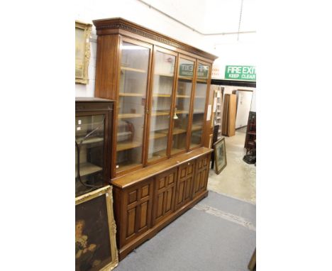 A good 19th century oak library cupboard bookcase with dentil moulded cornice, four glazed doors enclosing adjustable shelves