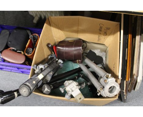 A quantity of camera tripods, monopods, camera lenses and a cine camera.