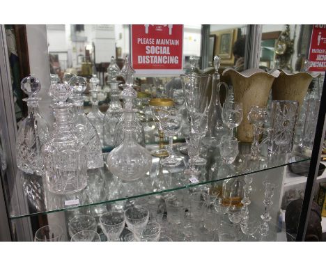 A shelf of cut glassware to include decanters, vases etc.