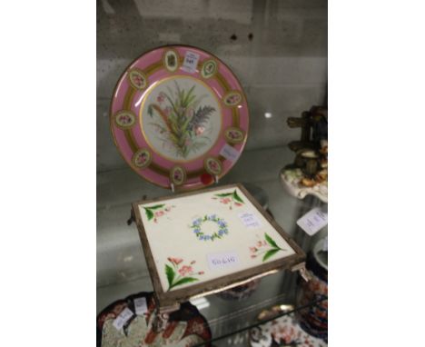 A cabinet plate, pink ground with gilt decoration, the centre painted with a floral spray, together with a Minton tile stand 