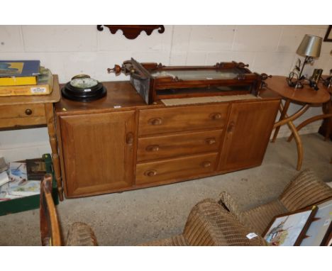 An Ercol sideboard fitted three central drawers flanked left and right by cupboards 