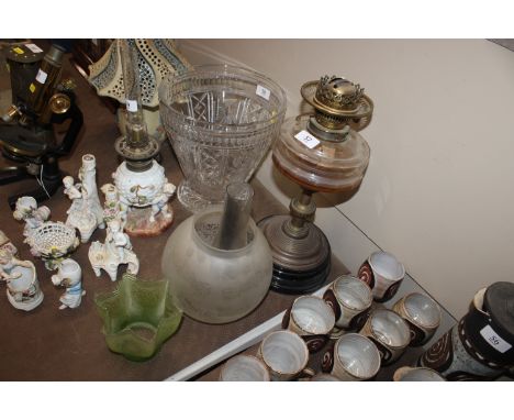 A Victorian brass column oil lamp complete with shade and chimney and a green tinted and etched lampshade 