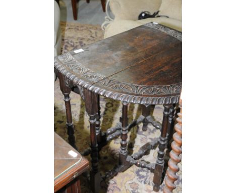 Oak drop leaf gate leg table with carved detail to the top and turned supports 