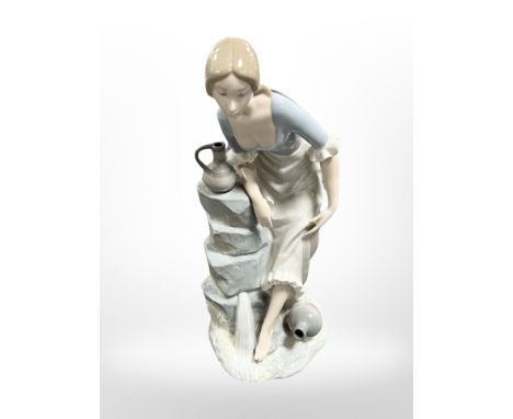 A Nao figure of a lady at a well, height 34cm.