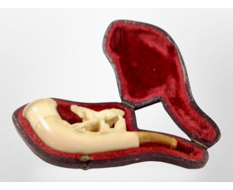 A vintage Meerschaum pipe in a fitted red velvet-lined case.