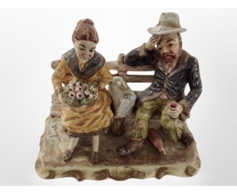 A Capodimonte figure of a lady and gentleman seated on a bench, height 27cm.