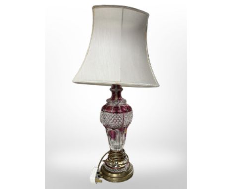 A two-tone cranberry glass brass-mounted table lamp with shade, overall height 65 cm. 