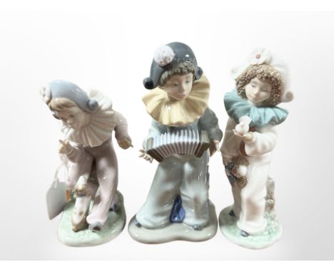 A Nao figure of a child playing acordion and two others.