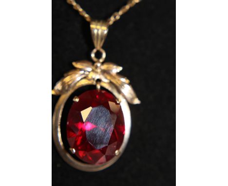 A large Ruby in a 14ct gold pendant on a 9ct gold chain 