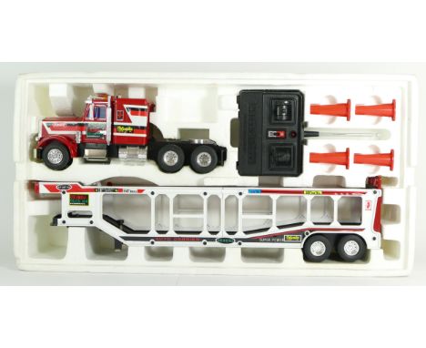 A remote control Peterbilt auto-carrier truck, by Radio Elecon, with remote, cones and instructions, in original box. togethe