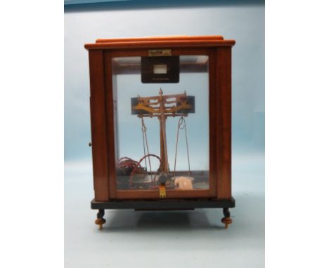 An unusual Oertling chemist's scale, early electric operation, lacquered brass with chrome pans, within glazed mahogany cabin