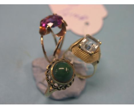 A 9ct. gold jade dress ring, and two yellow metal rings, aquamarine and amethyst, all solitaires