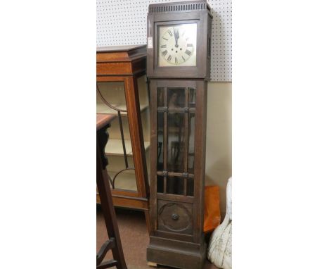 An early 20th century longcase clock, 11in. square, silvered dial with chiming movement, dark oak case with glazed trunk, 6ft