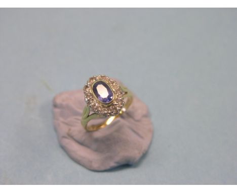 An 18ct. gold diamond and sapphire cluster ring, set pale oval sapphire and small diamonds, size J/K