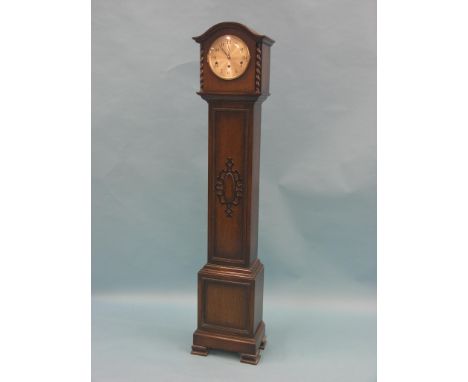 A 1920's dark oak-veneered grandmother clock, with silvered dial and chiming movement, with key and pendulum, 4ft. 10in.
