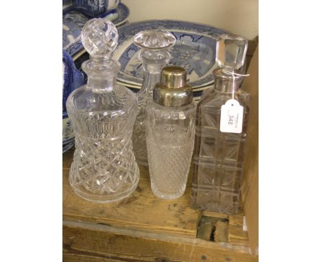 A cut glass spirit decanter, with white metal mount, two other cut glass decanters, all with stoppers, and a cut glass cockta