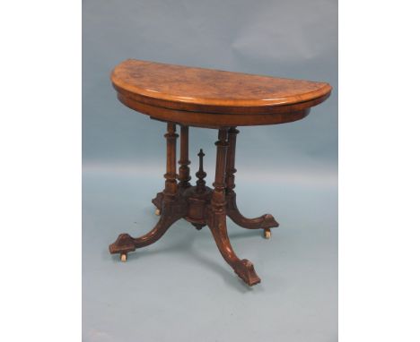 A Victorian inlaid burr walnut card table, half-round shape, on stem with four turned columns, four carved outswept legs with