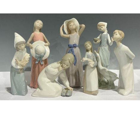 A Lladro figure, Girl holding Hat, 26cm high; others, Girl with Goose; Girl Wearing Hat; Girl with Slippers; etc, some faults