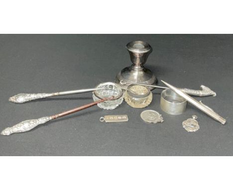 A silver candlestick, Birmingham 1958;  silver ingot pendant, napkin ring, medal, silver hafted button hooks, sterling silver