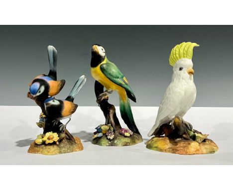 A Royal Crown Derby model, Macaw, painted by Lyndsey Selley, signed, 17cm high; others, Cockatoo, painted by J. Roome; Fairy 