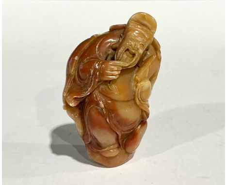 A Chinese soapstone seal, carved as an immortal stroking his beard
