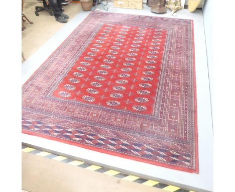 A red-ground machine made Tekke design carpet. 300x200cm. 
