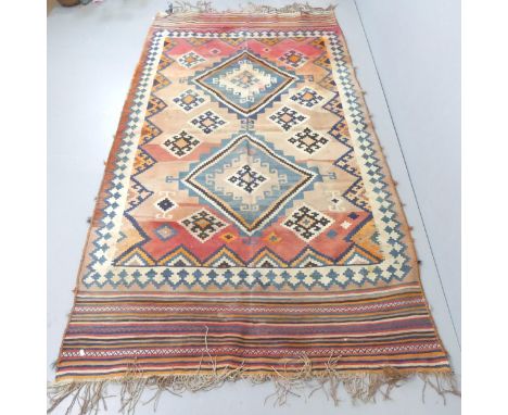 A red-ground Kilim carpet. 275x150cm.Some fading, particularly to corners. 