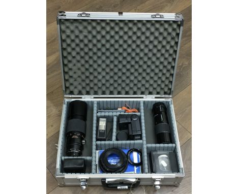 A case containing camera equipment including lenses and a Yashica flash