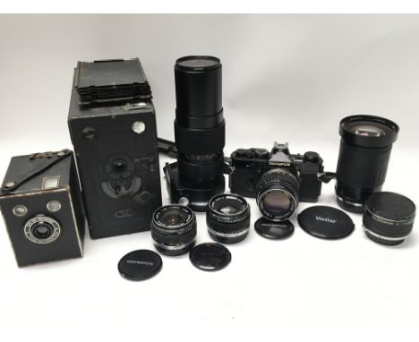 A box containing a collection of cameras including an Olympus OM-1 with lenses - 100mm f2.8, 85-250mm f5, 100mm f2.8, 28-210m
