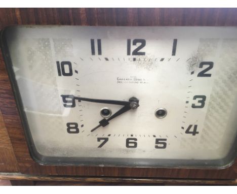 A oak Camerer Cuss mantle clock the silvered dial with Arabic numerals .