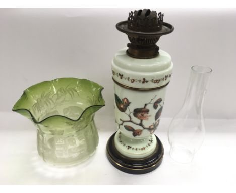 A milk glass oil lamp with decoration of fruiting branches. The green glass shade with acid etched decoration of elephants in
