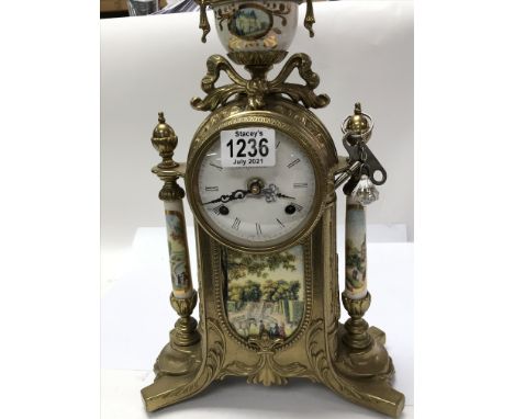 A 19th century style pretty gilt metal mantle clock, set with a dial with Roman numerals inset with porcelain panels of a dep
