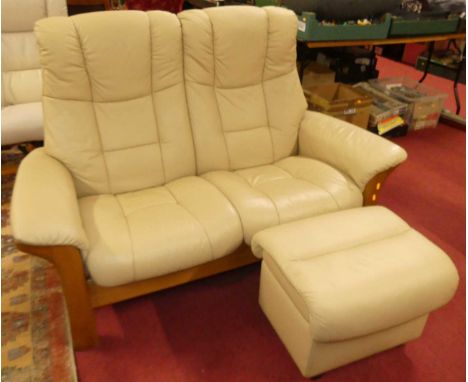 A leather upholstered Stressless reclining two seater sofa and matching footstool.