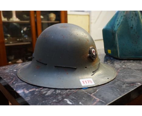 A World War II period tin helmet, inscribed 'MMOR 3-41', and with red cross badge. 