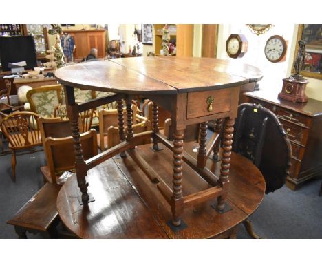 An early 18th century oak gateleg table, with frieze drawer and bobbin turned legs,&nbsp;108.5cm wide when open. 