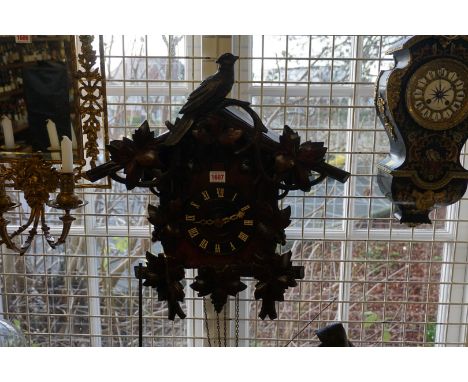 A Swiss carved walnut cuckoo wall clock,&nbsp;53cm high x 48cm wide, with two pine cone weights and pendulum.&nbsp; 