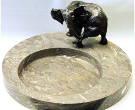 Cast bronze elephant model, 13cm high, standing on a circular, mottled grey marble panel with offset circular depression, 36c