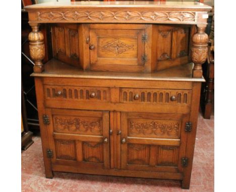 20th century carved oak buffet with two frieze drawers, two panel doors and a single panel door above, 126cm wide.