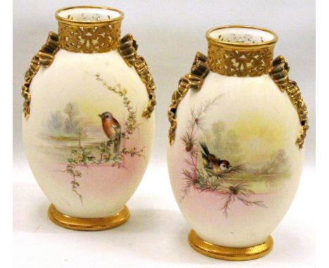 Pair of Grainger & Co., Worcester vases with opposing songbird vignettes, gilt ribboned handles and base, pierced gilt collar