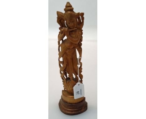 A Chinese boxwood figure of a female Deity playing a flute on a lotus flower carved base and demi-lune stepped plinth