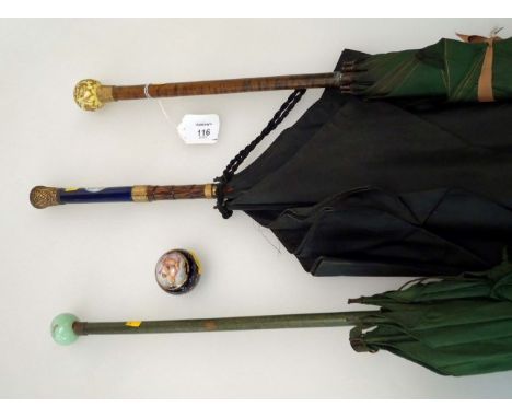 An early 20th century lady’s green parasol, with yellow ground, continental porcelain pommel with portrait within raised gilt