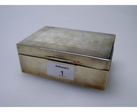 An early 20th century presentation silver cigarette box, with engine turned decoration and the legend 'Joyous Greeting' Sando