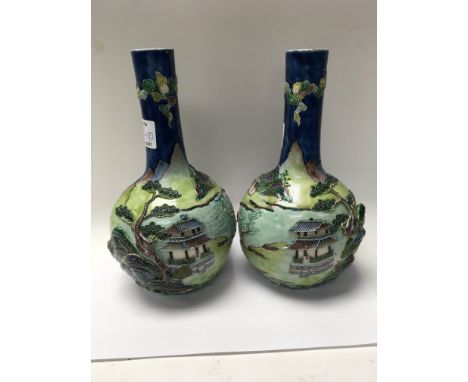 A pair of Chinese bottle vases decorated with raised landscape view 23 cm approximately in height With impressed seal mark .