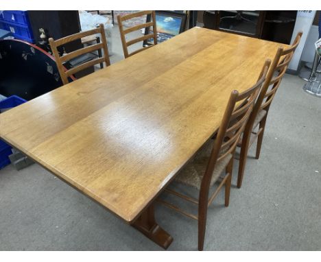 A 1930s oak refectory table together with 4 rush seated ladder backed dining chairs.