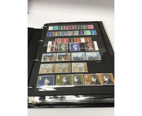 A stock book that contains a post 1970s mint GB collection of stamps with many traffic light and gutter blocks.