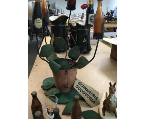 A Collection of Guinness Advertising including a tree and three figures and a lighter.