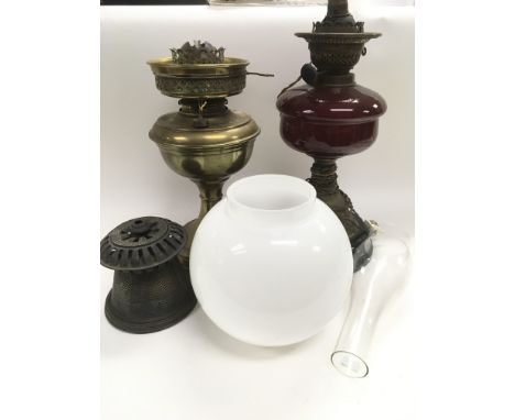 Two oil lamps, one with a ruby glass reservoir.