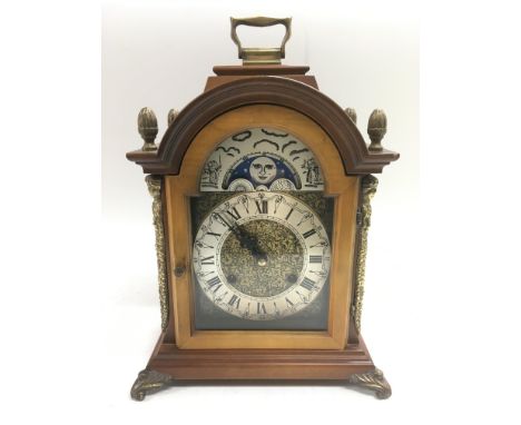 A moon phase mantle clock with brass dial and Roman numerals.