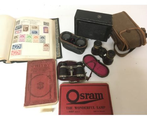 A collection of opera glasses cameras including quarter plate folding camera a stamp album Osram lamp book and other oddments